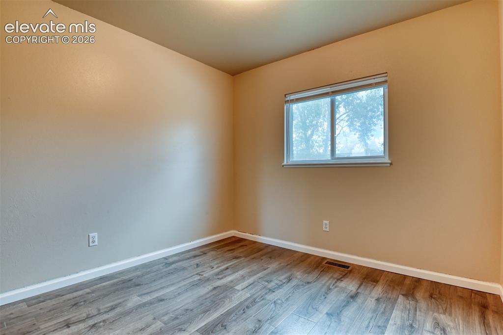 Image 29 of 50: Neutral tone walls complemented by wood-finish flooring