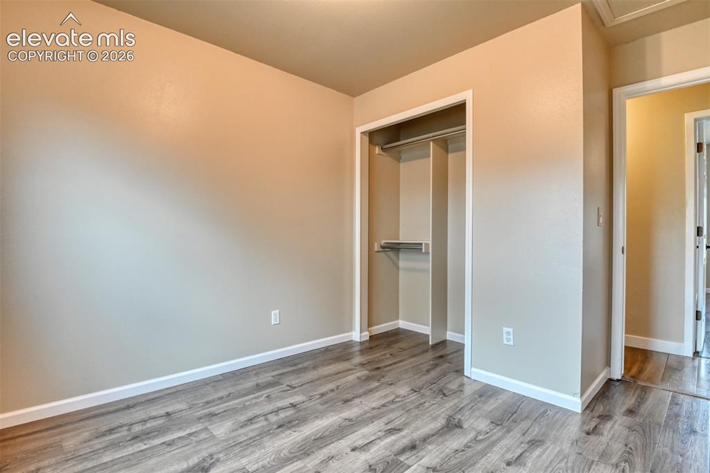 Image 31 of 50: Interior room featuring wood-finish flooring, light-colored walls, white ba