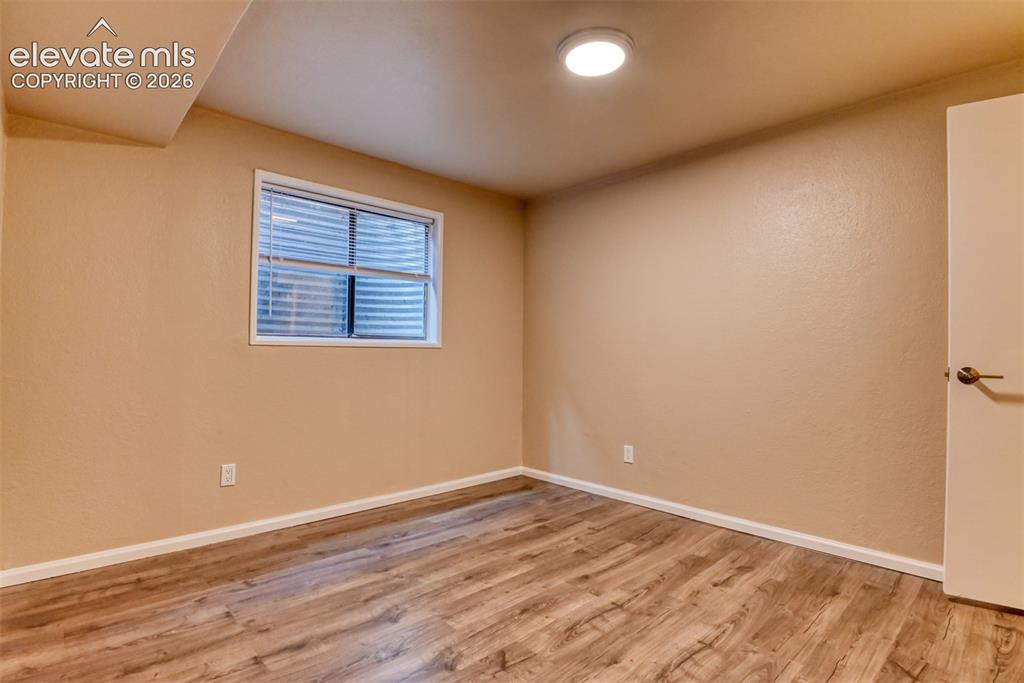 Image 38 of 50: Basement bedroom with 3/4 attached bath. Room featuring wood-finish floorin