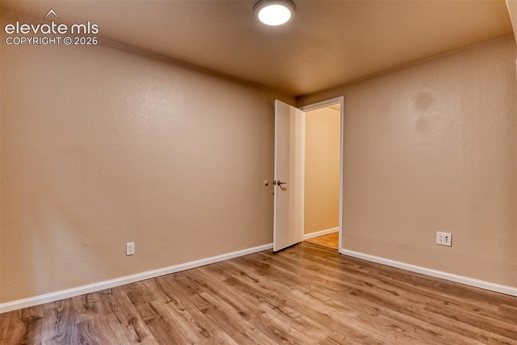 Image 39 of 50: Basement bedroom with 3/4 attached bath. Interior room featuring wood-finis