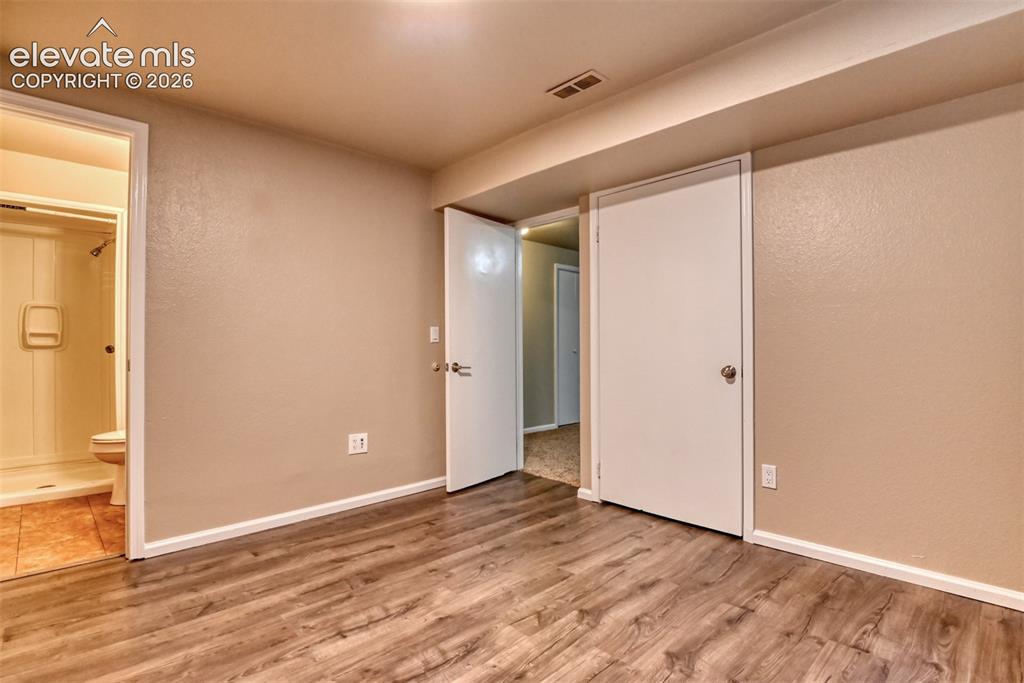 Image 40 of 50: Basement bedroom with 3/4 attached bath.Room featuring wood-finish flooring