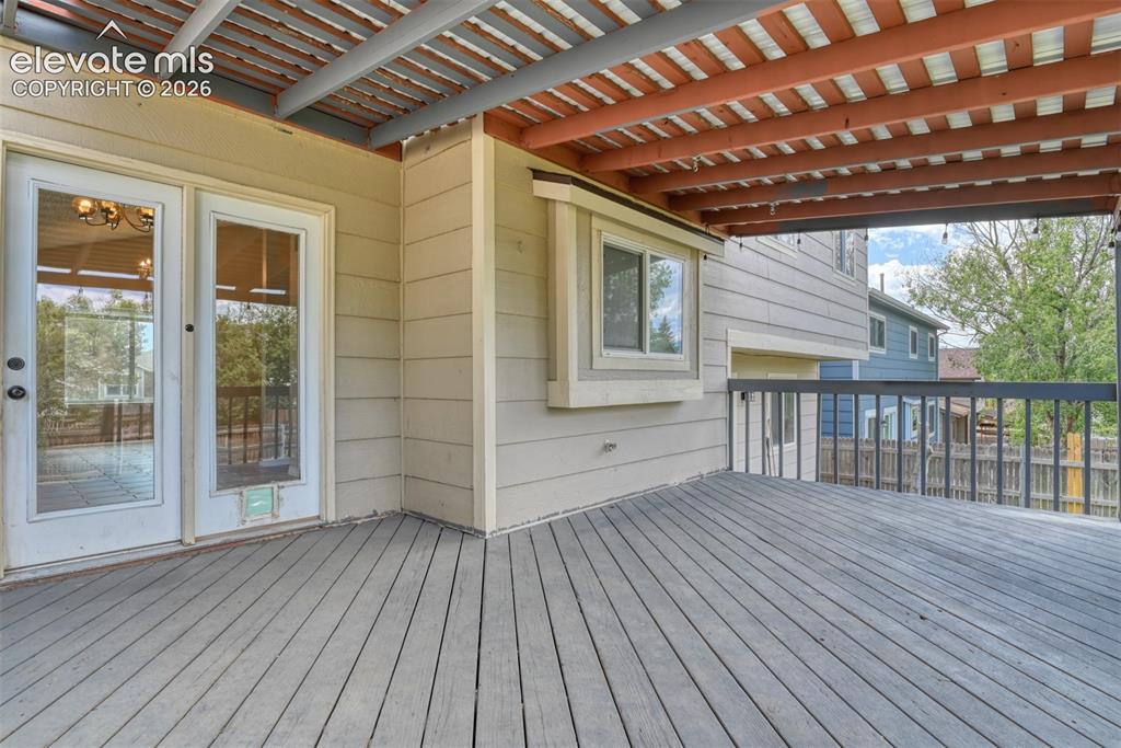 Image 46 of 50: Expansive outdoor deck featuring wood-finish flooring and dark railings