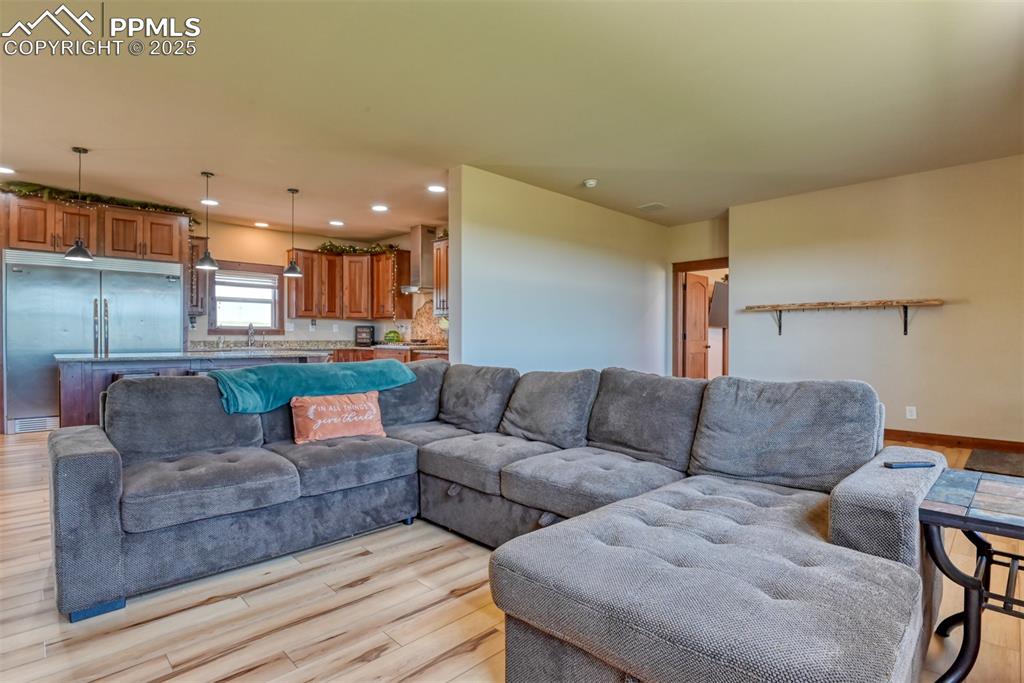 Image 10 of 47: Living area with light wood-style floors and recessed lighting