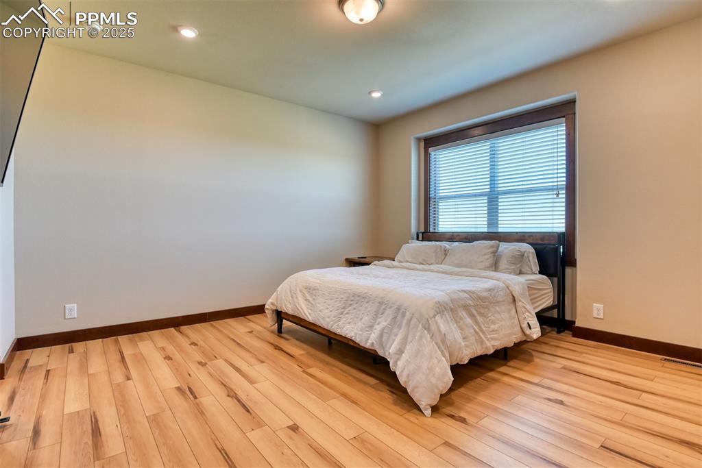 Image 13 of 47: Bedroom featuring light wood-type flooring and recessed lighting