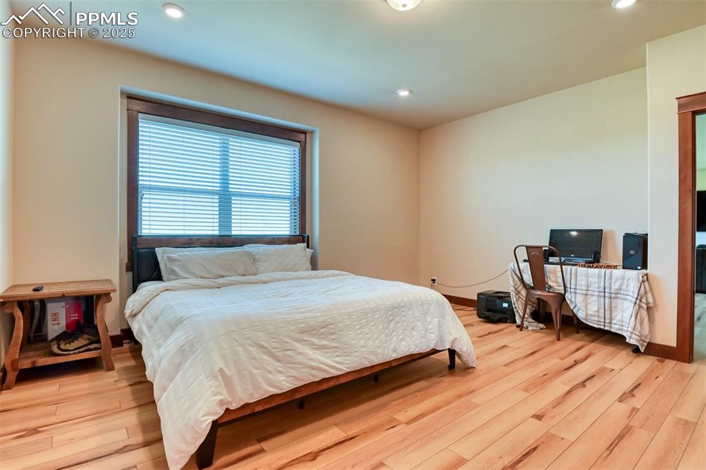 Image 15 of 47: Bedroom featuring LVT wood style floors and recessed lighting