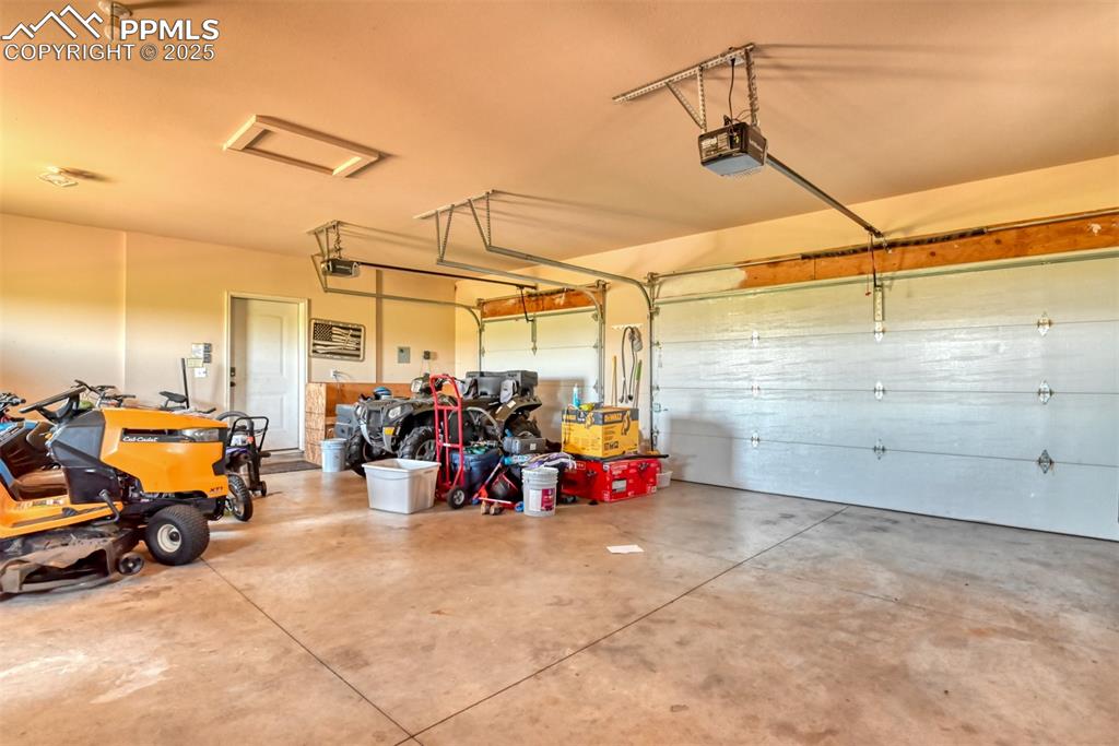 Image 30 of 47: Garage featuring a garage door opener