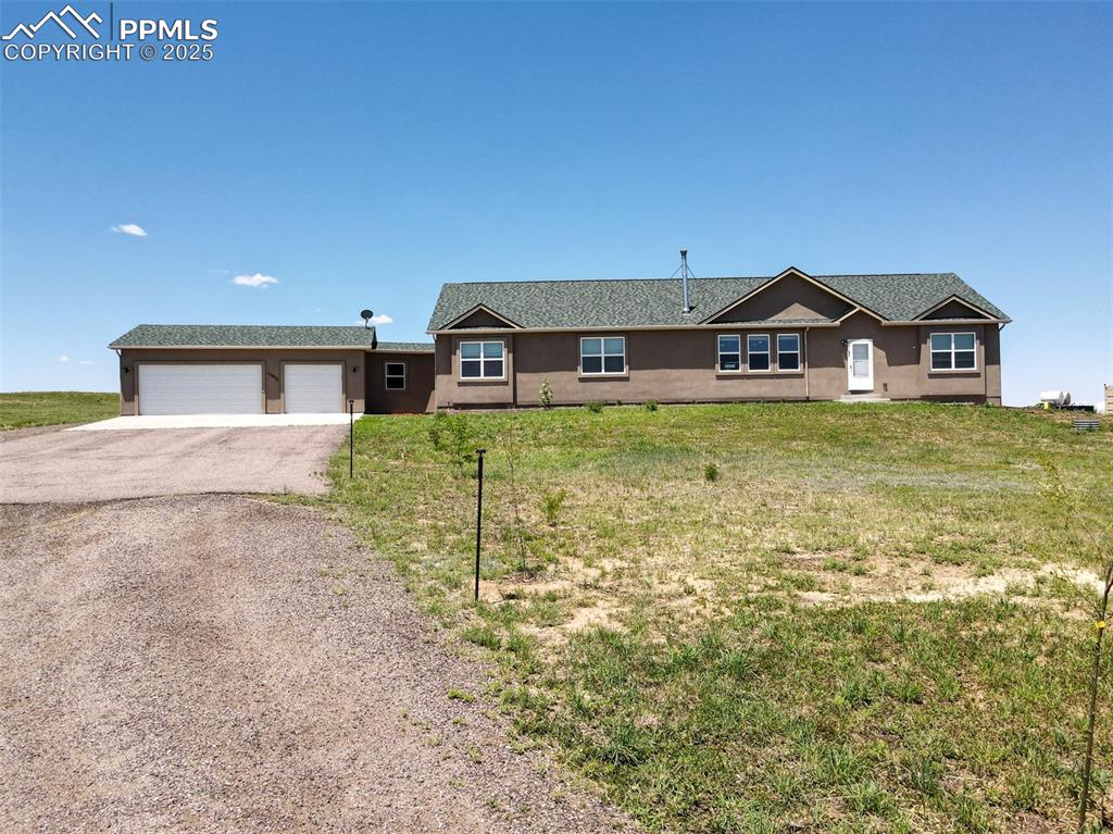 Image 32 of 47: Single story home featuring asphalt driveway, stucco siding, and a front la