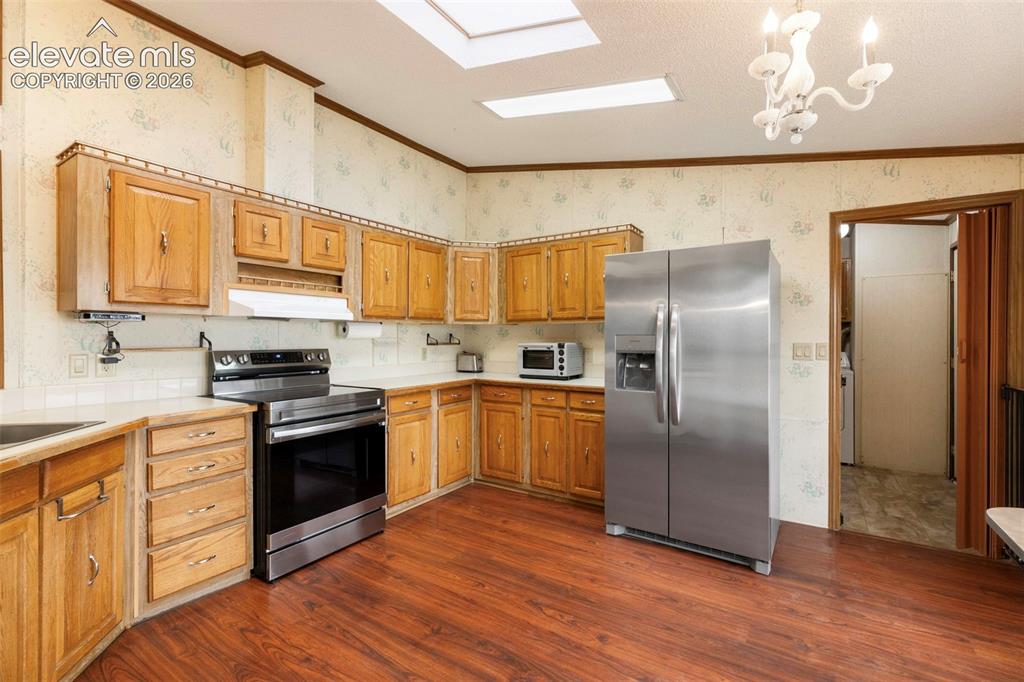 Image 11 of 38: Kitchen featuring wood-finish flooring and a full suite of stainless steel