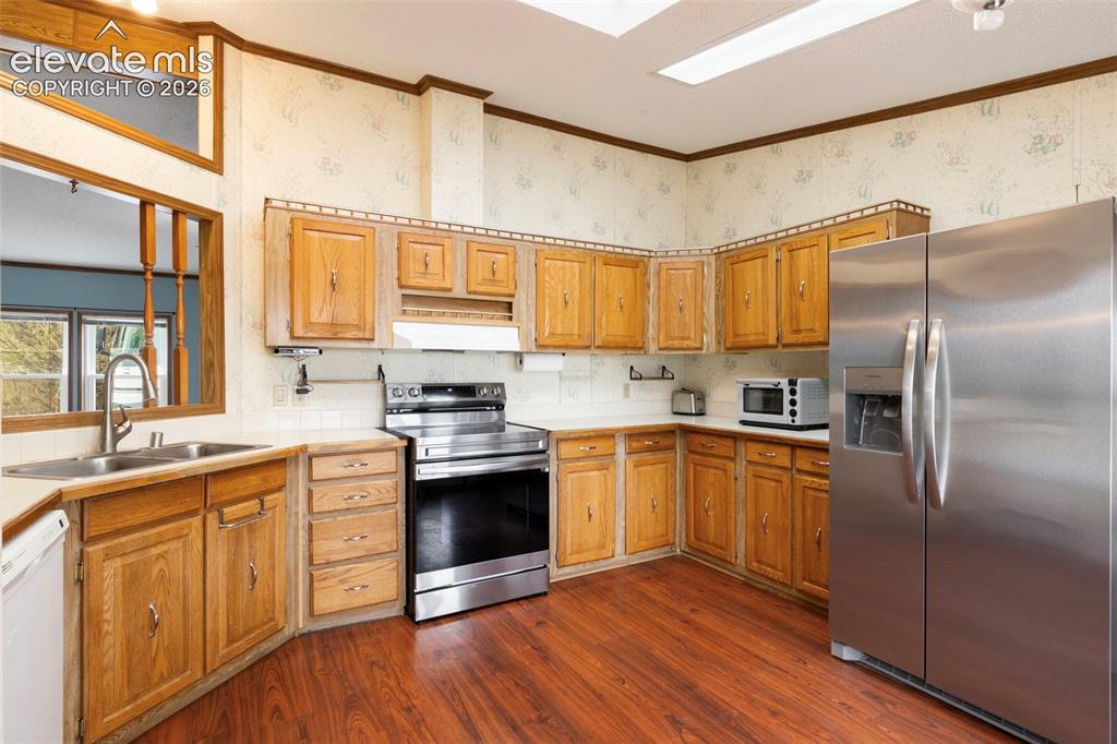 Image 12 of 38: Kitchen featuring wood cabinetry, wood-finish flooring, and a stainless ste