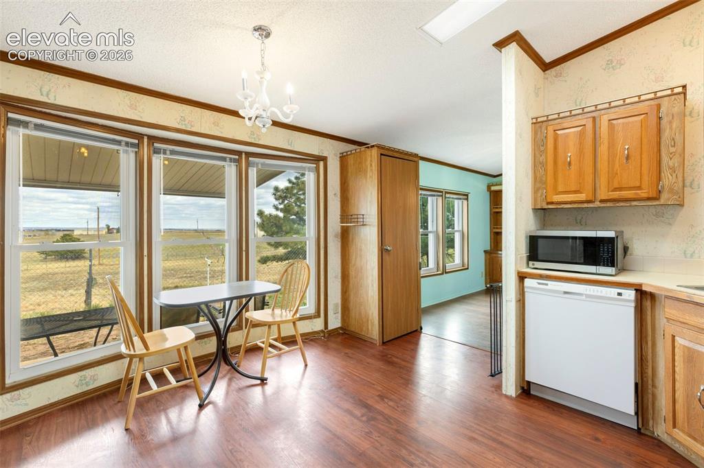 Image 13 of 38: Bright dining area featuring a trio of large windows with expansive outdoor