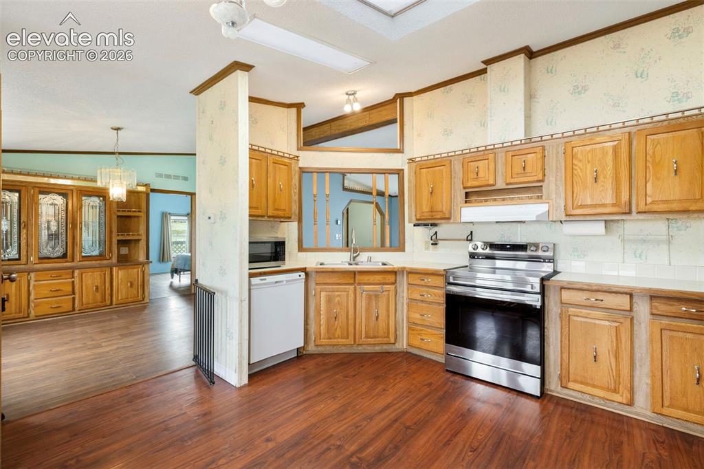 Image 14 of 38: Kitchen featuring wood-finish flooring, wood cabinetry, white countertops,