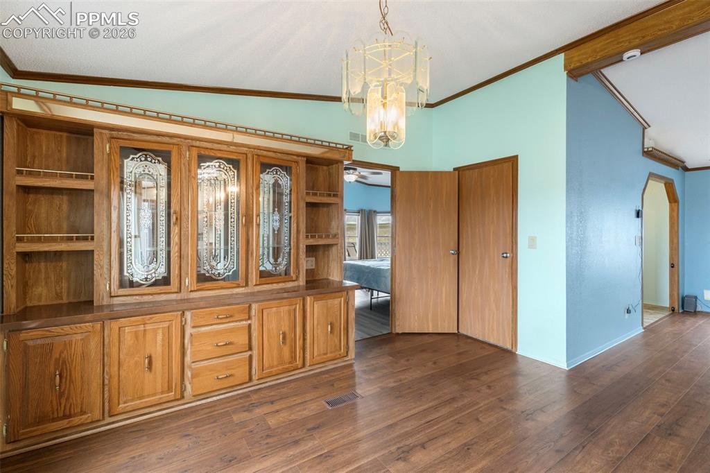 Image 15 of 38: Built-in wood-finish cabinetry featuring decorative glass door inserts and