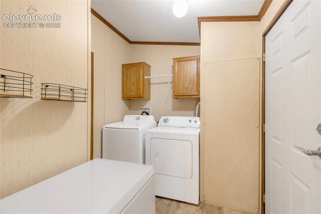 Image 15 of 38: Dedicated utility room featuring wall-mounted cabinetry, a built-in shelf w
