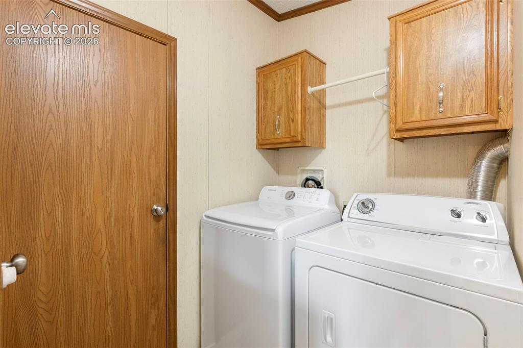 Image 16 of 38: Dedicated laundry space featuring a white top-load washer and dryer set, tw