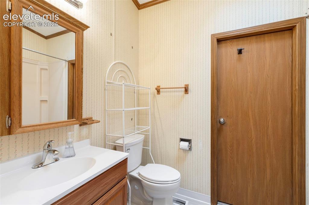 Image 17 of 38: Bathroom featuring a wood-finish vanity with an integrated sink and chrome