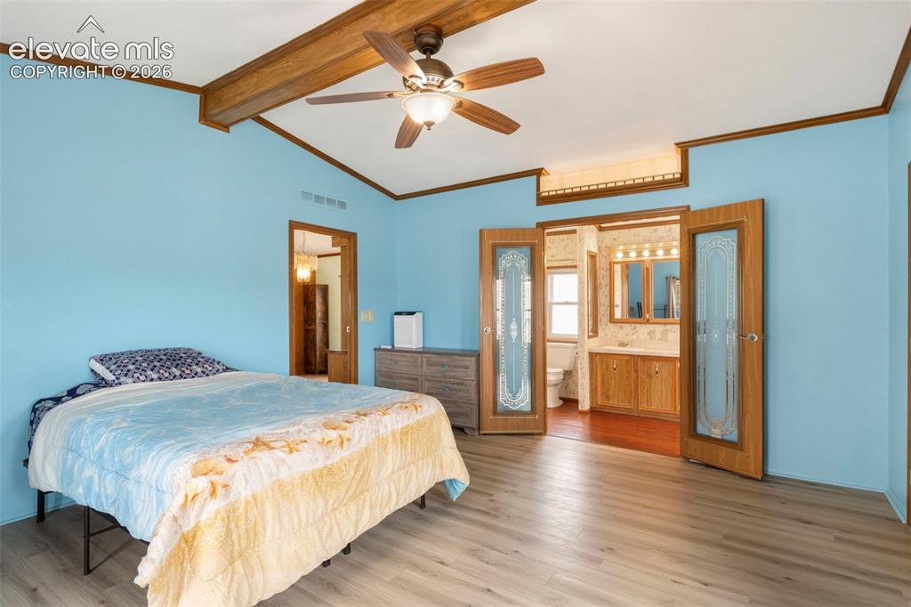 Image 19 of 38: Vaulted ceiling featuring exposed wood beams and a ceiling fan with integra
