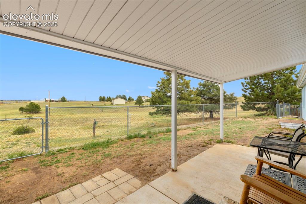 Image 25 of 38: Covered patio featuring a concrete slab and a metal roof structure