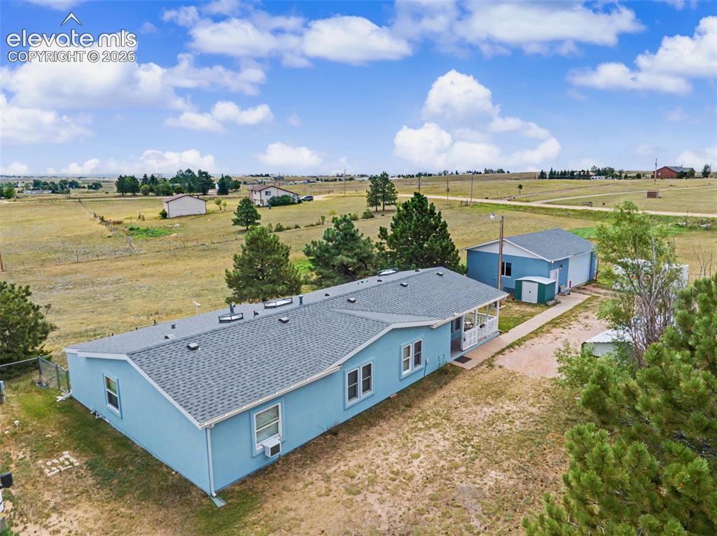 Image 27 of 38: Light blue exterior residence with an asphalt shingle roof, accompanied by