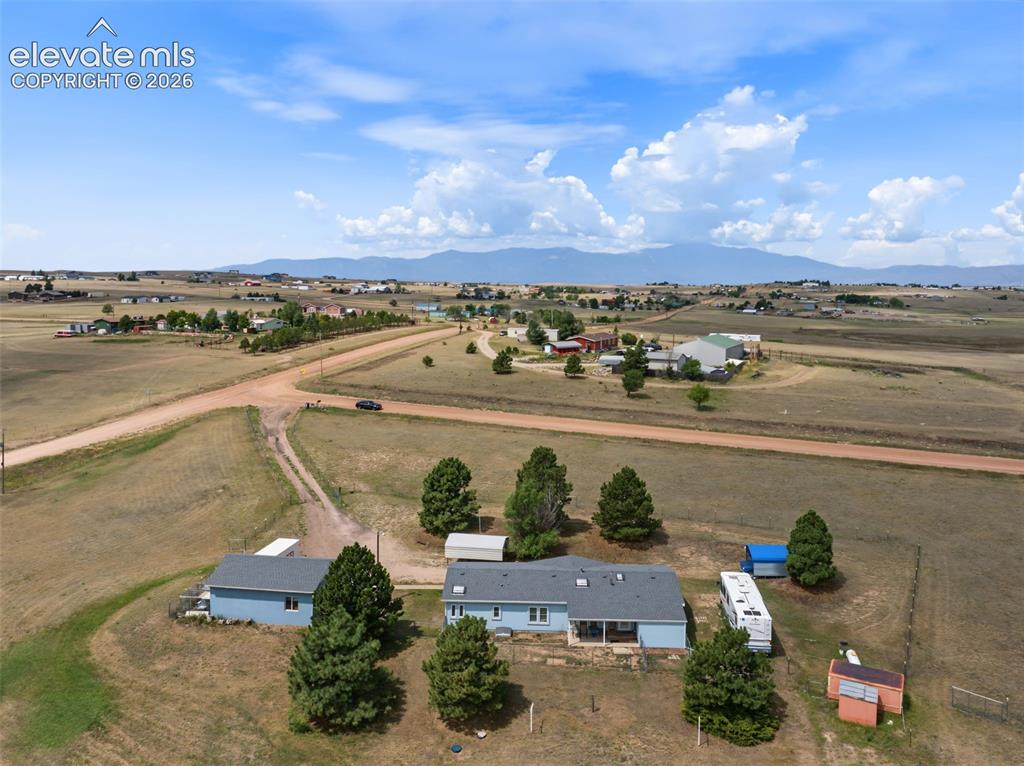 Image 30 of 38: Expansive rural property featuring two light blue residential structures, m