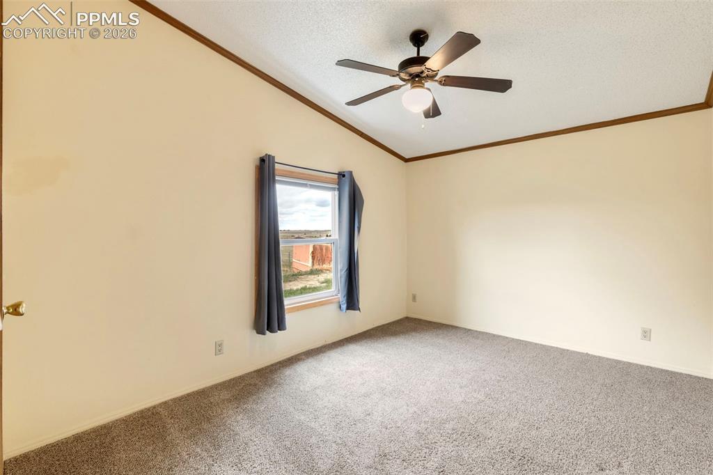 Image 32 of 38: Carpeted room featuring a single window, a ceiling fan with integrated ligh