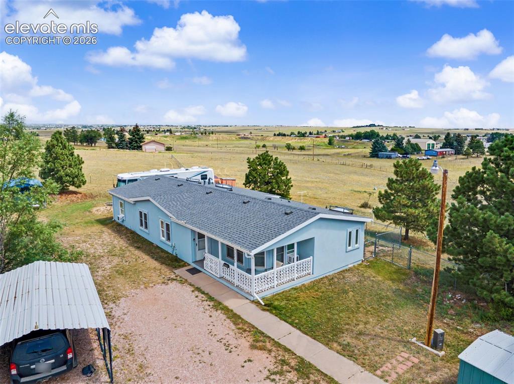 Image 34 of 38: Light blue ranch-style residence featuring a covered front porch with white