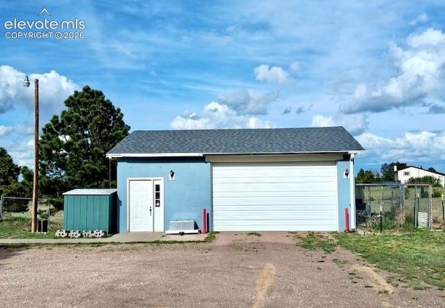 Image 37 of 38: Standalone garage structure featuring a light blue exterior, a large white