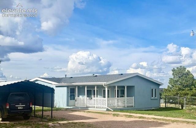 Image 38 of 38: Light blue single-story residence with a covered front porch featuring whit