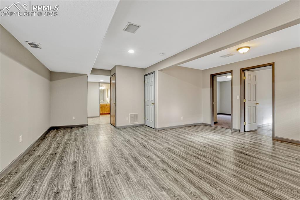 Image 11 of 47: Finished basement with laminate flooring and recessed lighting