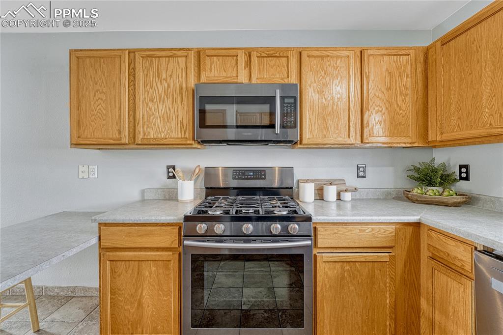 Image 21 of 47: Gas range oven and overhead microwave