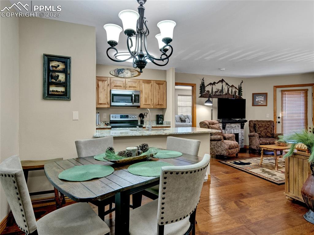 Image 11 of 22: Dining room with wood finished floors and an inviting chandelier