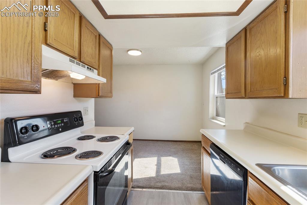 Image 16 of 32: Main level kitchen and dining room area, faces the back of the condo, all a