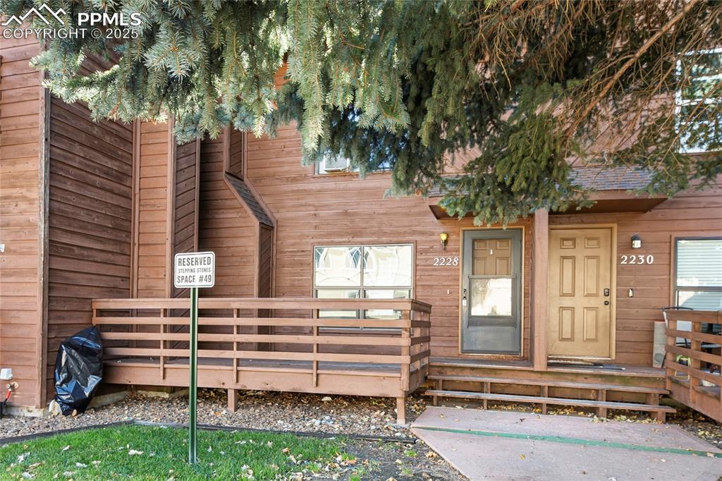 Image 2 of 32: Front door entry to condo with deck