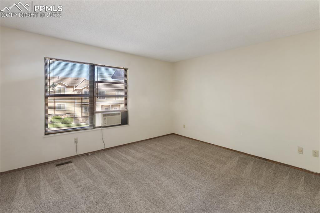 Image 21 of 32: Upper level bedroom #2 that faces the front of the condo, window a/c unit a