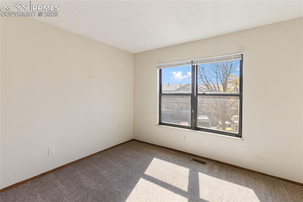Image 30 of 32: Upper level bedroom #1 that faces the back of the condo