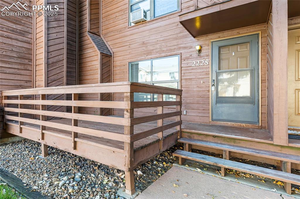 Image 5 of 32: Front entry with deck to condo