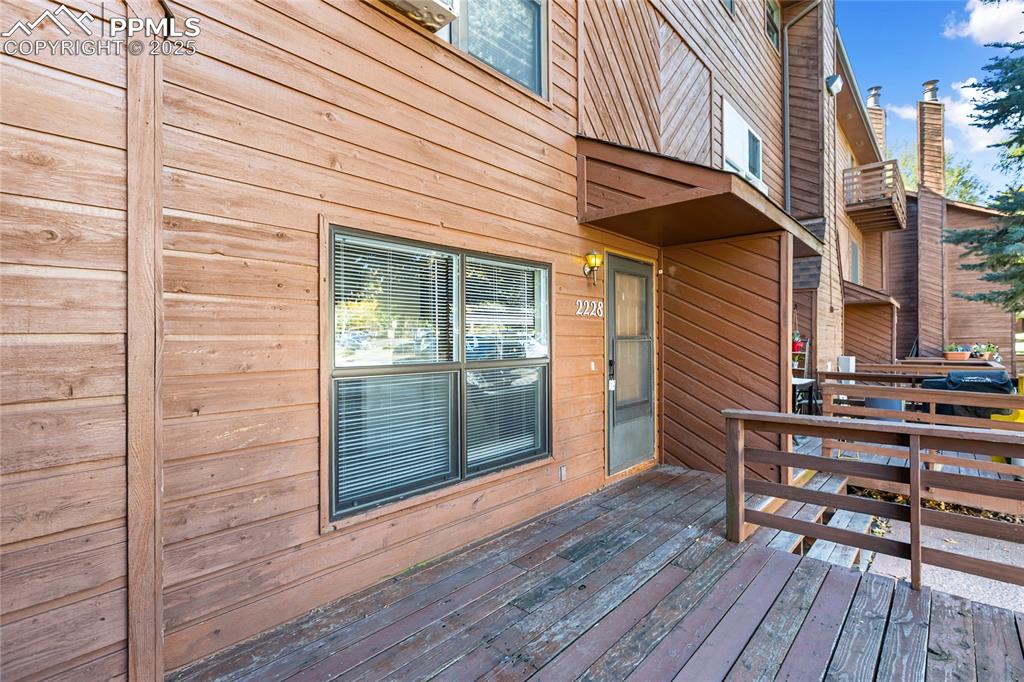 Image 6 of 32: Front entrance of condo with deck