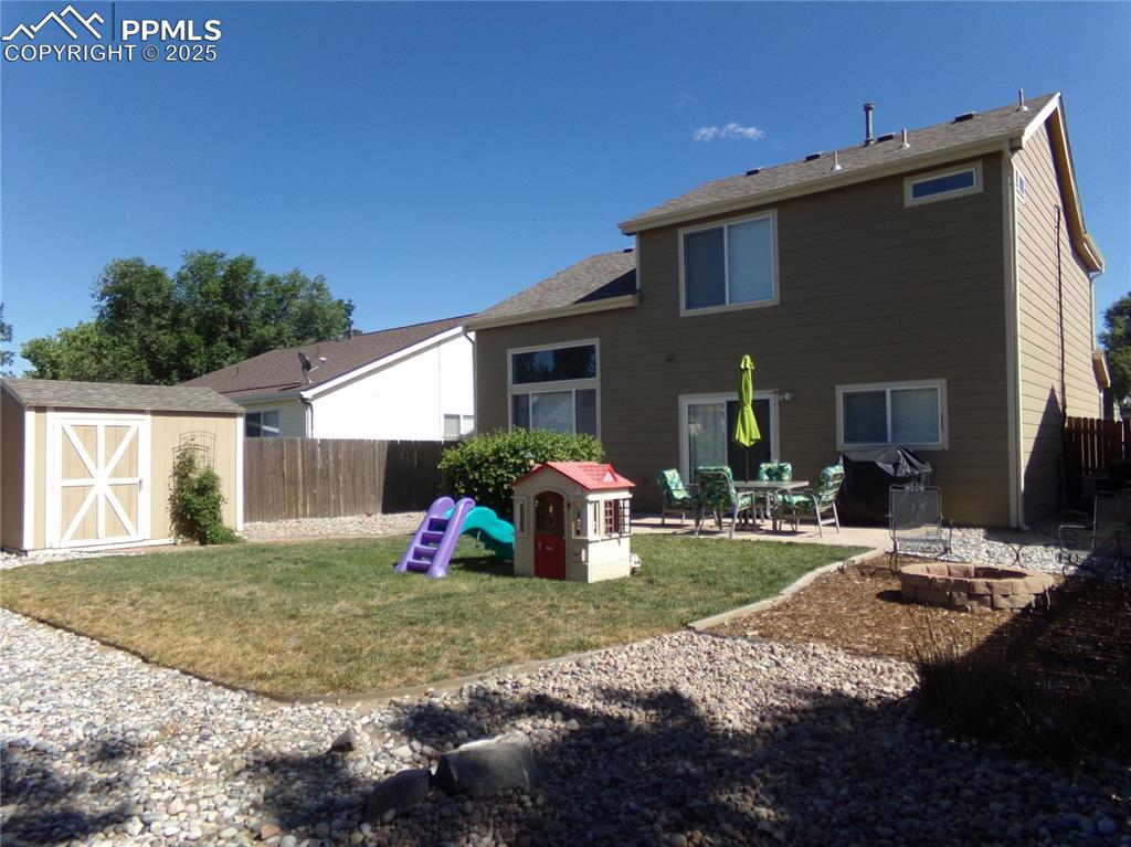 Image 21 of 22: Back of house with a storage unit and a patio area
