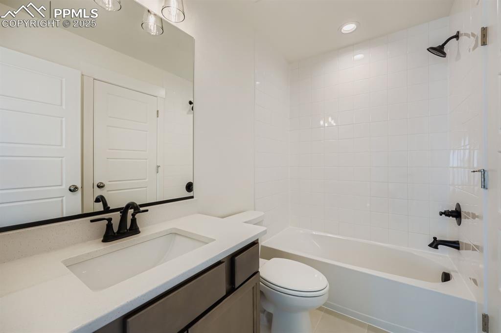 Image 18 of 28: Full bathroom with vanity,  shower combination, light tile patterned floori