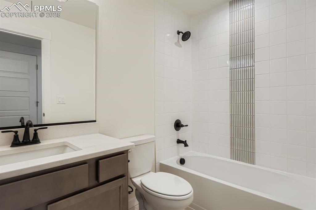 Image 20 of 28: Bathroom with vanity and bathtub / shower combination