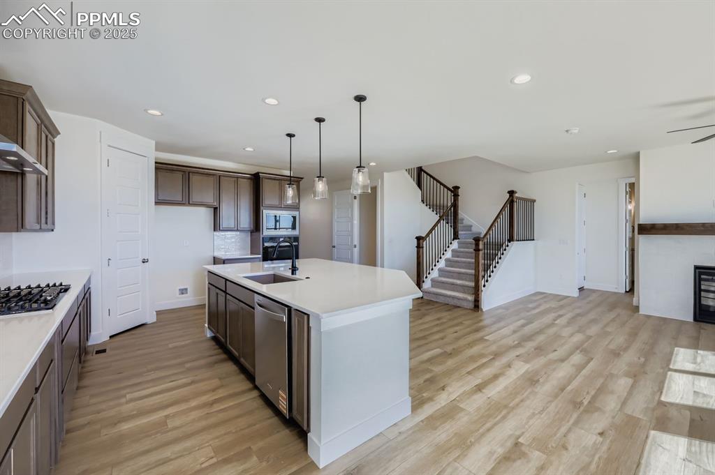 Image 8 of 28: Kitchen with pendant lighting, a center island with sink, recessed lighting