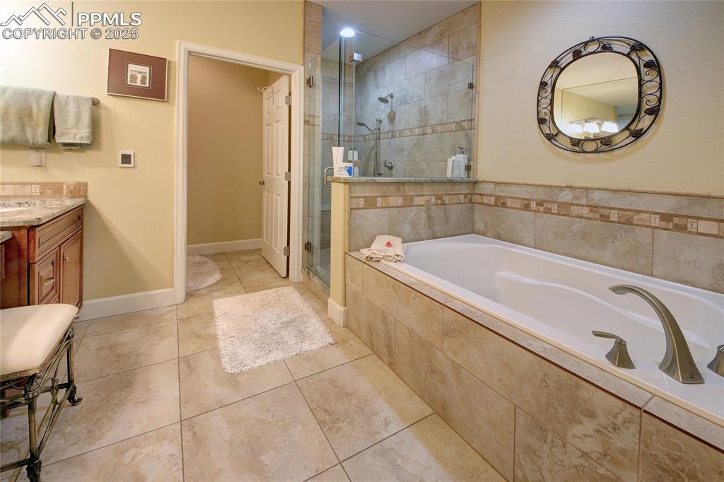 Image 18 of 36: The 5-piece master bath has a large tub, stand alone shower, double sinks, 