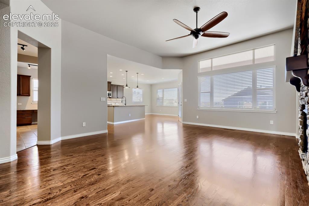 Image 5 of 50: Living room with picture windows, stone fireplace, open concept design, gor