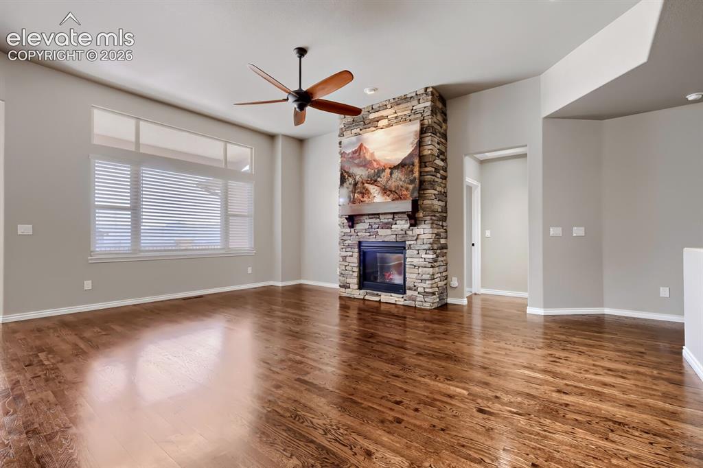 Image 7 of 50: Living room with picture windows, stone fireplace, open concept design, gor
