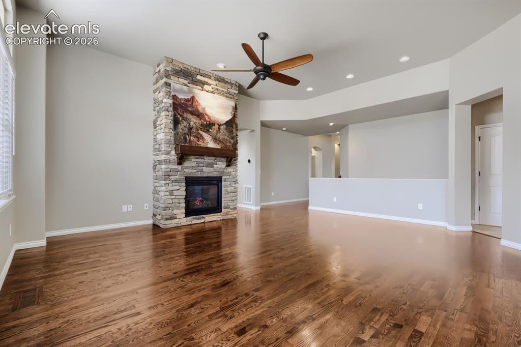 Image 9 of 50: Living room with picture windows, stone fireplace, open concept design, gor