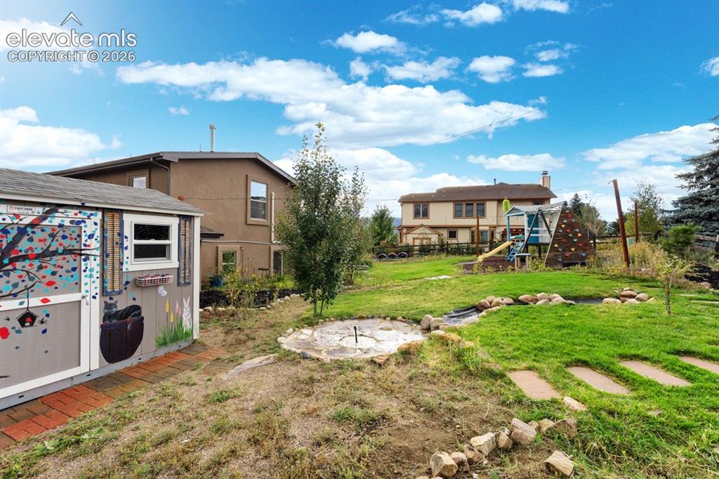 Image 13 of 50: Expansive backyard featuring a manicured lawn, established trees, and a dec