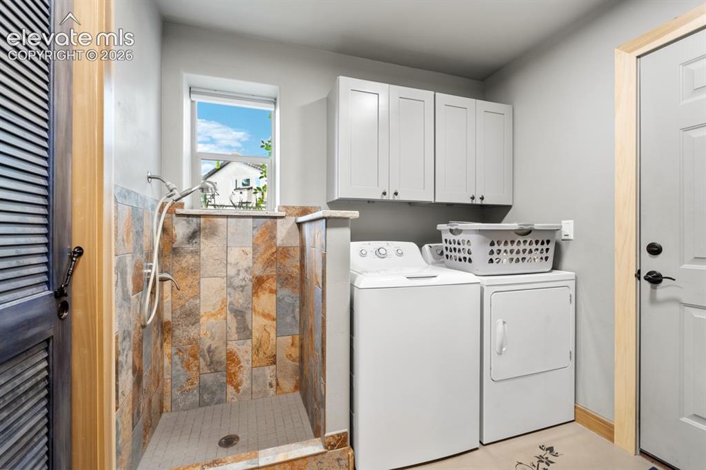 Image 15 of 50: Built-in shower with natural stone-look tile surround and mosaic floor