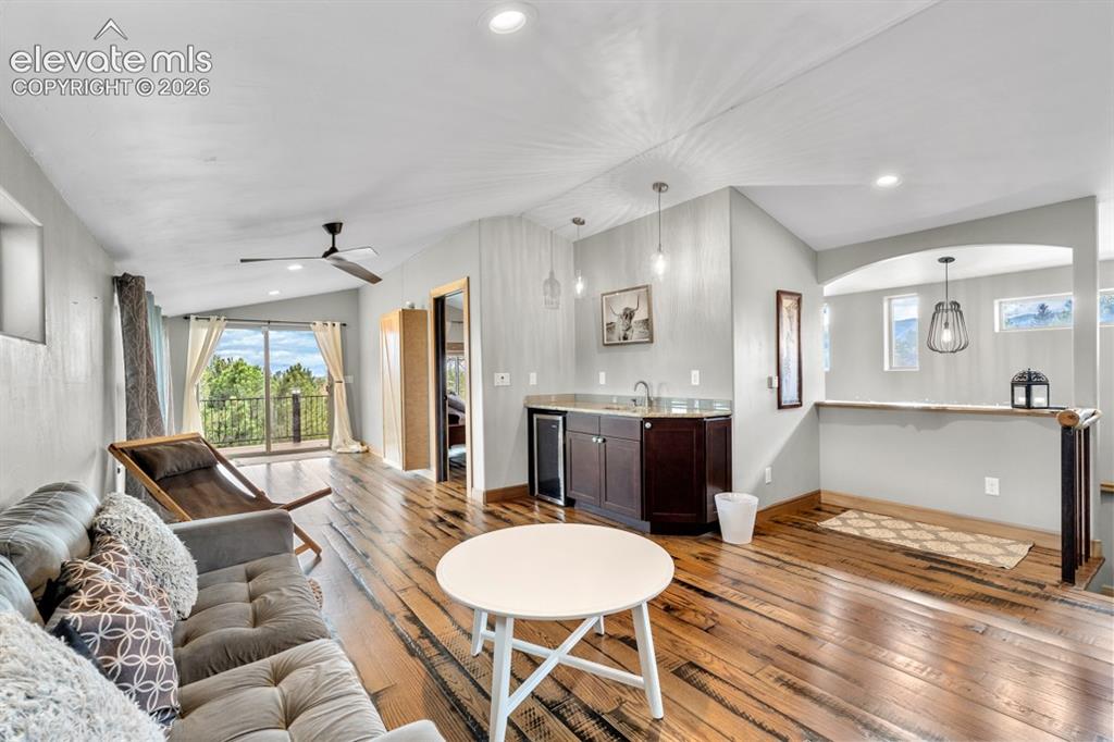 Image 17 of 50: Vaulted ceiling with recessed lighting, wood-finish flooring, built-in wet