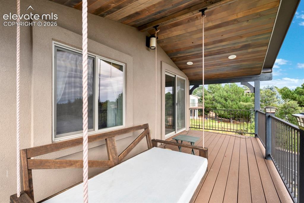 Image 23 of 50: Spacious outdoor deck with composite decking, a wood-paneled ceiling, reces