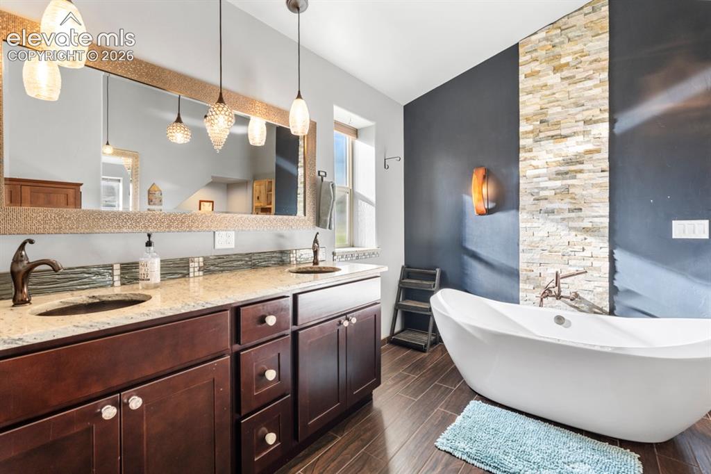 Image 33 of 50: Dual vanity with granite countertops, rich wood cabinetry, and oil-rubbed b