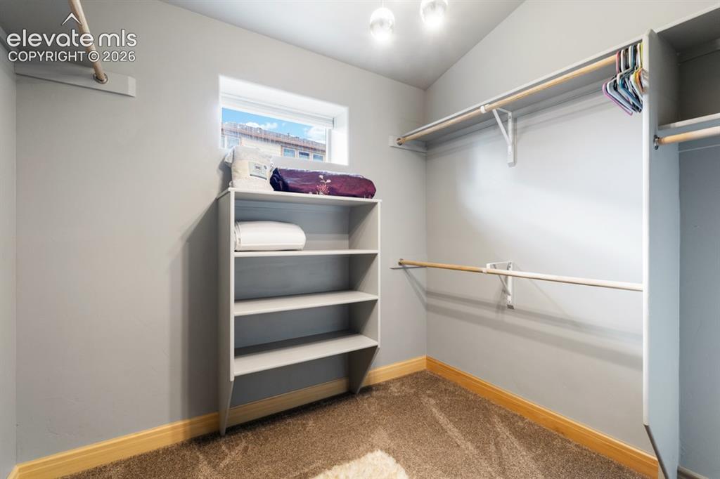 Image 38 of 50: Built-in closet shelving, multiple hanging rods, recessed window, overhead 